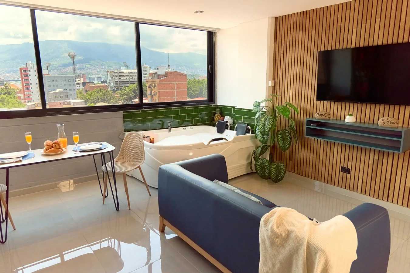 Living area of a furnished Rosa Negra apartment with a soaking tub and a view toward Medellín.