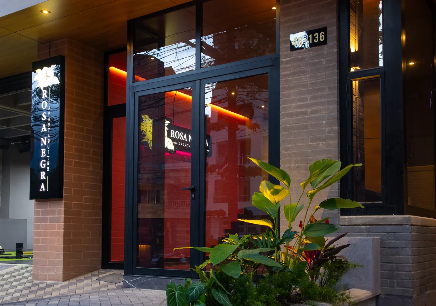 Entrance of Rosa Negra Aparta Suites in Medellín, with the building name on the door.