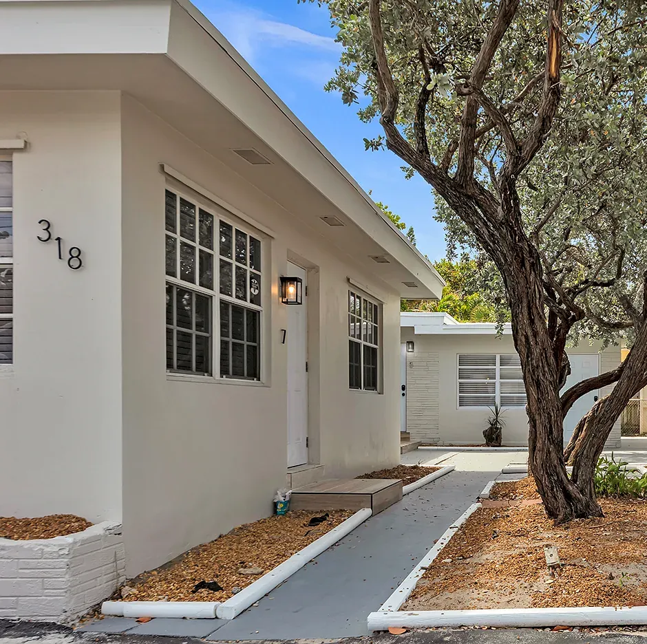 Courtyard at 318 Walnut Street in Hollywood, Florida, white one-story buildings in daylight.